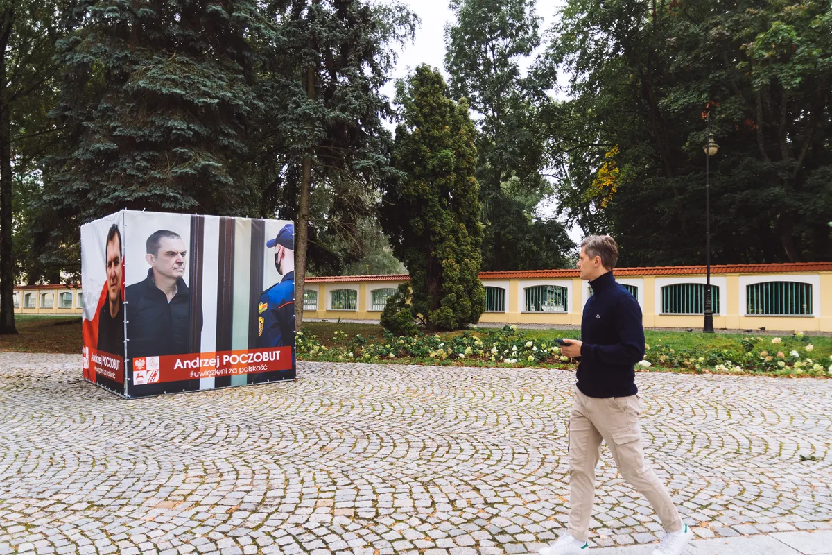 Руслан Кулевич у плаката в честь политзаключенного журналиста Анджея Почобута. Фото: Hrodna.life