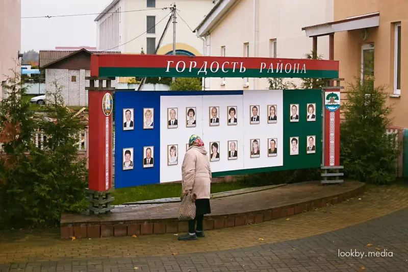 Меньше писем — больше доверия? Разбираемся, почему чиновники Гродненщины стали получать меньше жалоб Жанчына глядзіць на дошку гонару "Гонар раёна" недзе ў Астравецкім раёне © LookByMedia