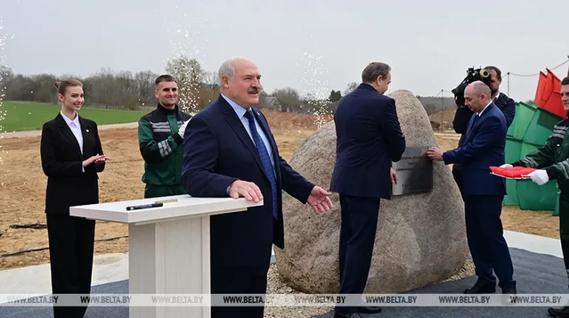 Лукашэнка на будпляцоўцы ў полі на Янкі Купалы расказвае пра заробкі ўрачоў. Справа - камень, куды заклалі "капсулу часу" з пасланнем