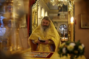 Расійскі свяшчэннік Сергій Баранаў чытае кнігу ў багата ўпрыгожаным Гродненскім саборы.